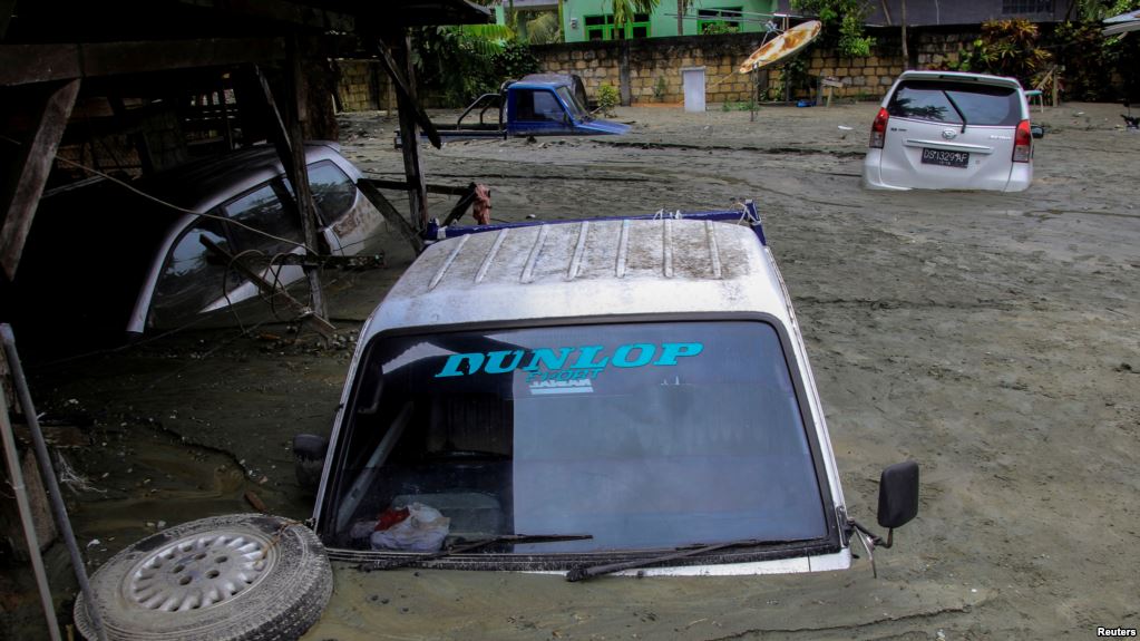 Mobil-mobil tampak terendam akibat bencana banjir dan tanah longsor di Sentani, Papua hari Minggu (17/3). (Foto. Gusti Tanati/Antara via Reuters/VOA)