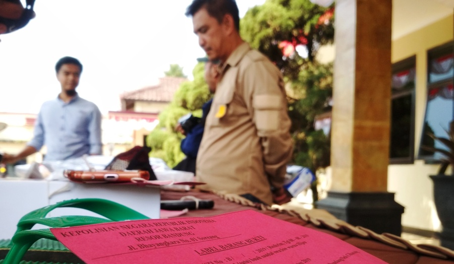 Anggota Satreskrim Polres Bandung memeriksa sejumlah barang bukti kasus pembunuhan FP terhadap NA saat gelar perkara di Mapolres Bandung, Soreang, Kabupaten Bandung, Kamis (8/8/2019). Foto: Muhammad Zein