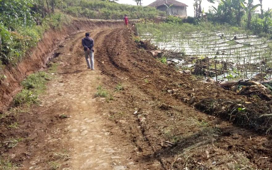 Seorang warga melintasi Jalan Poros Tengah yang mulai dibangun Pemkab Garut. Jalan itu akan menghubungkan Kecamatan Cilawu dengan Kecamatan Banjarwangi, Kabupaten Garut, Jawa Barat. Foto: Beni/dara.co.id