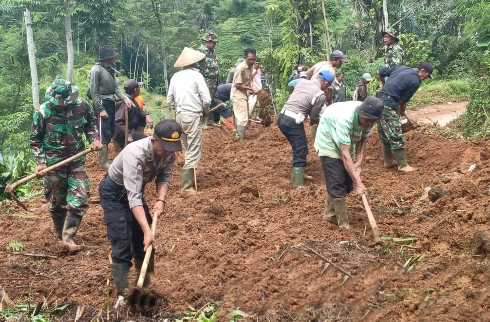 Sejumlah anggota Polsek Ciwidey, Pemerintah Kecamatan dan Koramil Ciwidey dibantu warga berusaha membersihkan material tanah pascalongsor di Desa Cipelah, Kecamatan Rancabali, Kabupaten Bandung, Senin (17/2/2020). Foto: Humas Polresta Bandung