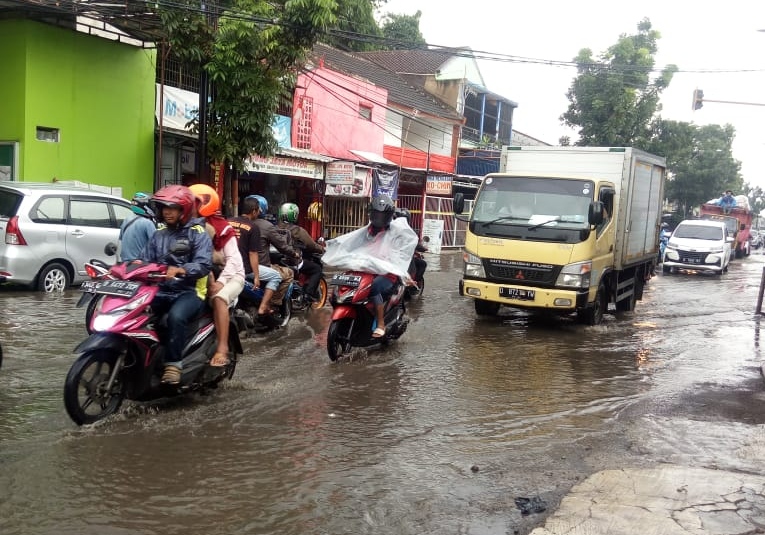 Sejumlah pengendara melintasi Jalan Terusan Kopo-Soreang tepatnya di Warunglobak, Kecamatan Katapang, kabupaten Bandung, Jawa Barat, yang tergenang akibat buruknya drainase. (Foto: Muhammad Zein/dara.co.id)