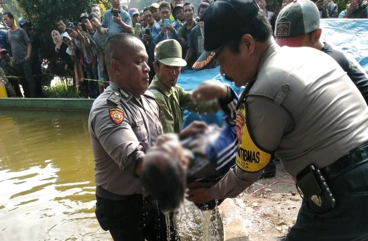 Sejumlah anggota Polsek Majalaya melakukan evakuasi sesosok mayat yang ditemukan mengambang di kolam Alun-alun Majalaya, Kabupaten Bandung, Jawa Barat, Rabu (4/3/2020). (Foto: Istimewa)