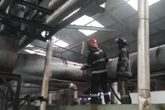 Dua petugas Damkar melakukan pemadaman api yang membakar cerobong milik PT Nusatex di Kecamatan Majalaya, Kabupaten bandung, Jawa Barat, Senin (9/3/2020). (Foto: Pusdalops Dinas Pemadam Kebakaran dan Penyelamatan Kabupaten Bandung)