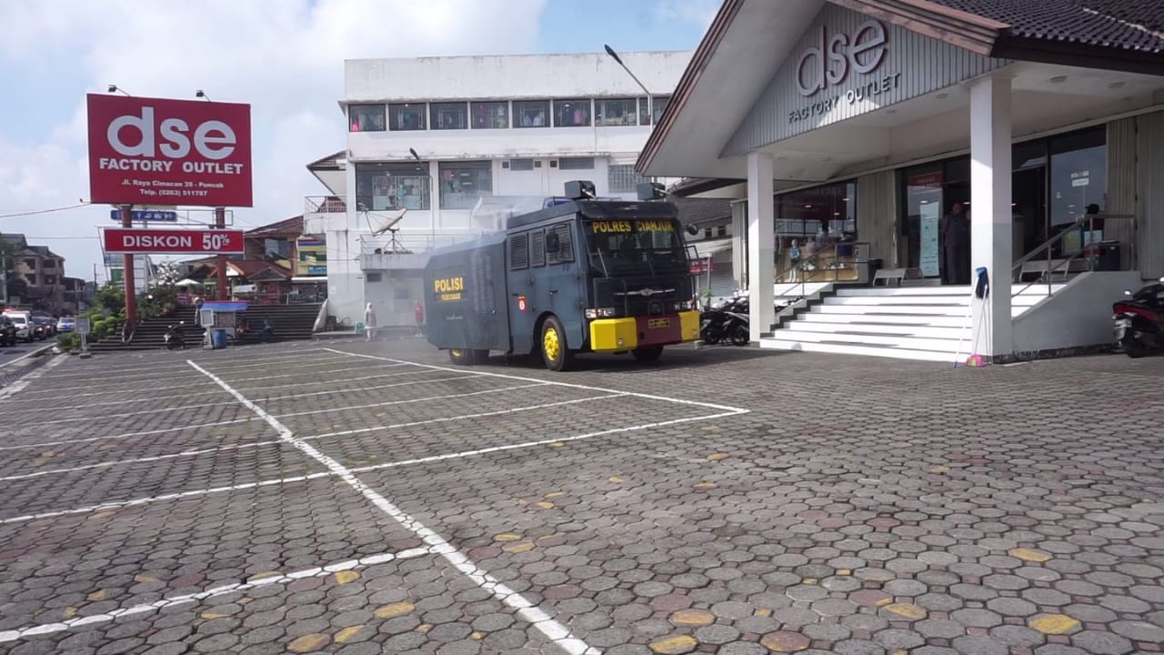 Mobil water cannon milik Polres Cianjur saat melakukan penyemprotan disinfektan di kawasan pusat perbelanjaan di Cipanas, Kabupaten Cianjur Jawa Barat, Selasa (24/3/2020). (Foto: Purwanda/dara.co.id)