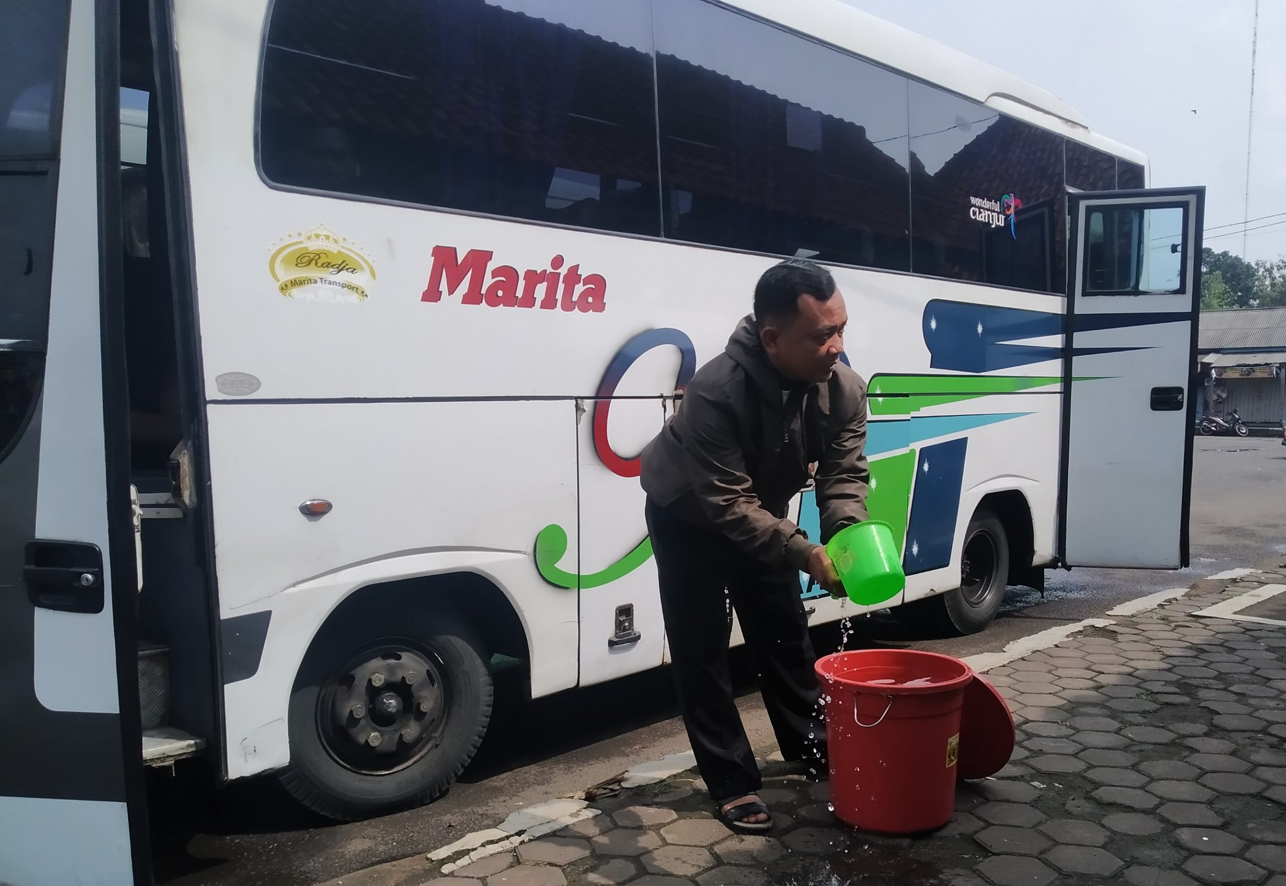 Seorang penumpang mencuci tangan dengan air yang sudah disediakan di Terminal Pasirhayam, Kabupaten Cianjur, Jawa Barat, (Foto: Purwanda/dara.co.id)