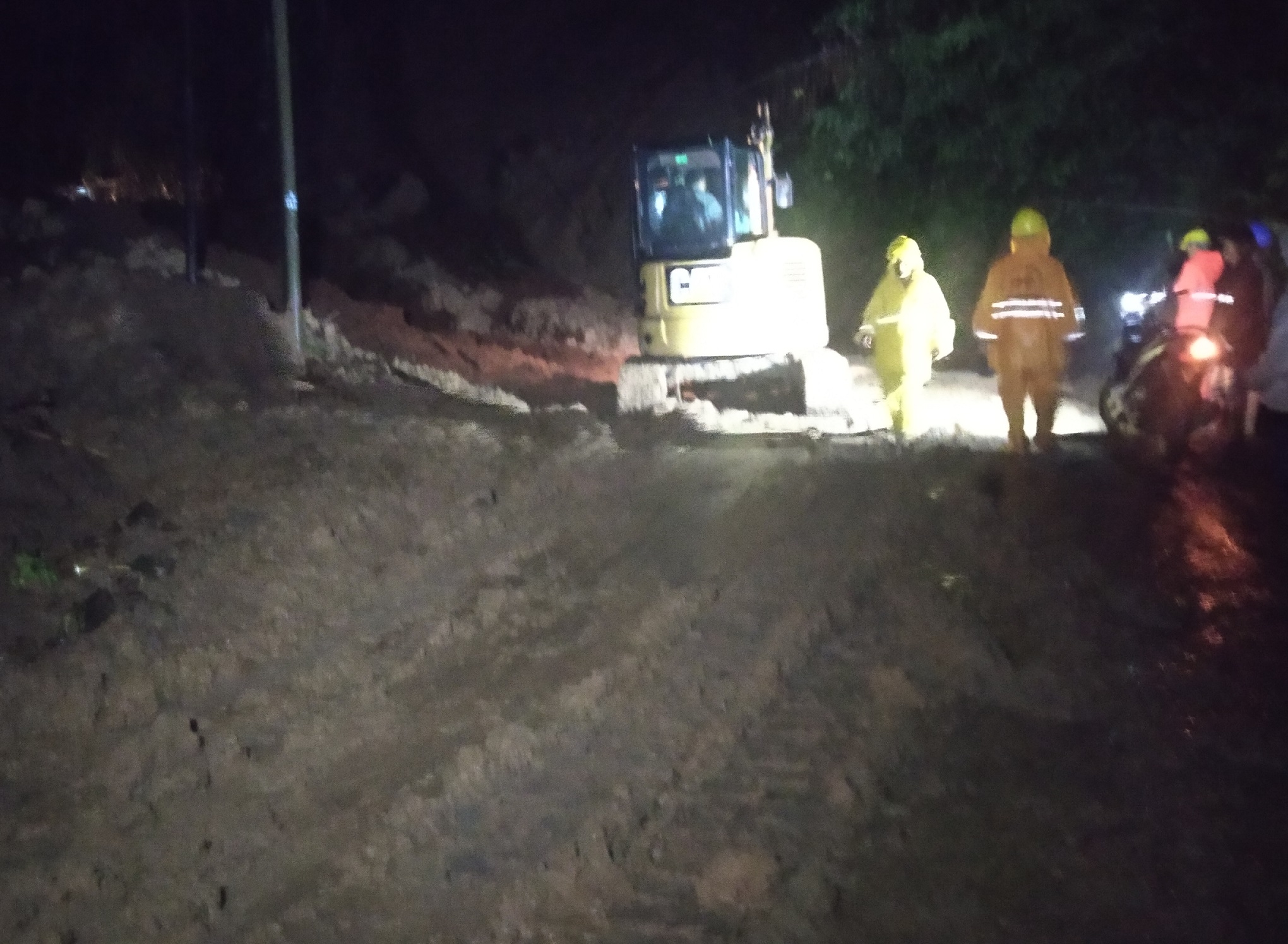 Sejumlah petugas dan satu unit beckhoe tengah melakukan evakuasi material longsor yang terjadi di Kecamatan Cibeber, Kabupaten Cianjur, Jawa Barat, Kamis (19/3/2020) malam. (Foto:Purwanda/istimewa)