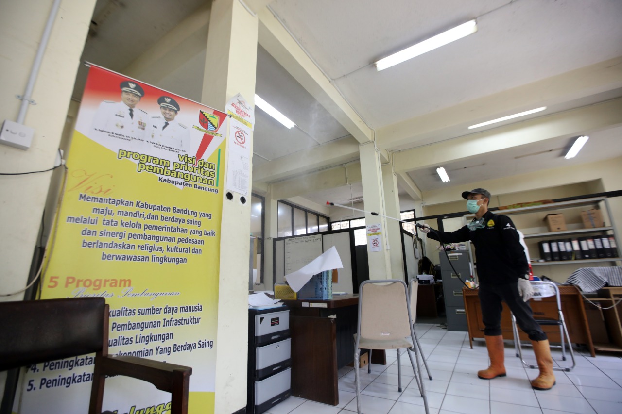 Seorang petugas Dinkes Kabupaten Bandung melakukan penyemprotan cairan disinfektan di salah satu kantor di lingkungan Komplek Pemkab Bandung, Soreang, Kabupaten Bandung, Jawa Barat. (Foto: Humas Setda Kabupaten Bandung)