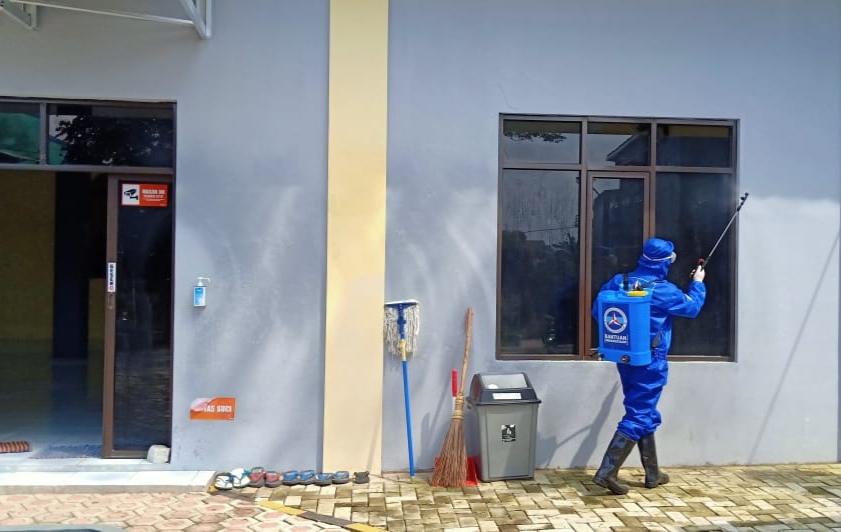 Seorang petugas dari DPC Partai Demokrat Kabupaten Bandung melakukan penyemprotan disinfektan di salah satu Masjid yang ada di Soreang, Kabupaten Bandung, Jawa Barat, Senin (13/4/2020). (Foto: Muhammad Zein/dara.co.id)