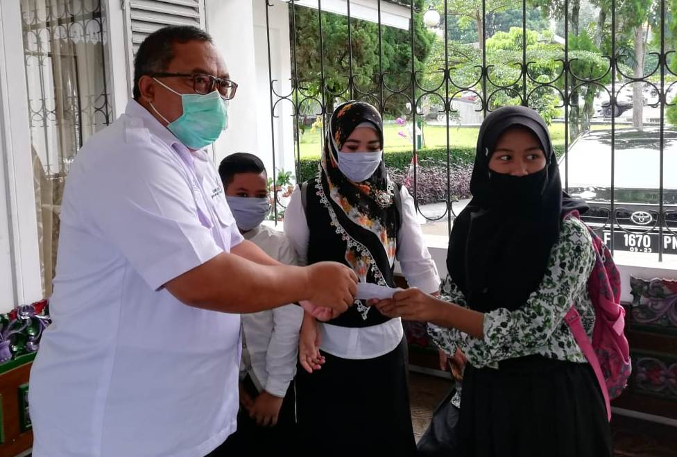 Bupati Sukabumi, Marwan Hamami secara simbolis menerima bantuan dari perwakilan pelajar di Kabupaten Sukabumi, Jawa Barat, untuk penanganan pandemi Covid-19 di Rumah Jabatannya, Kamis (23/4/2020). (Foto: Riri Satiri/dara.co.id)