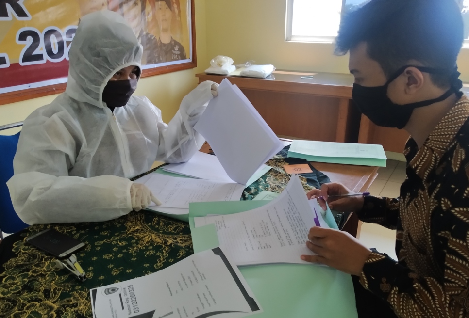 Seorang anggota Polri memverifikasi berkas pendaftaran calon anggota Polri di Aula Primkoppol Mapolres Cianjur, Kabupaten Cianjur, Jawa Barat, Rabu (15/4/2020). (Foto: Purwanda/dara.co.id)