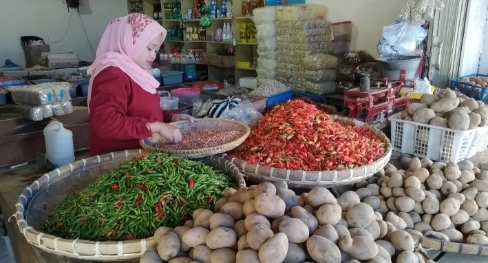 Salah seorang pedagang di Pasar Induk Pasirhayam, Cilaku, Kabupaten Cianjur, sedang memilah barang dagangannya. Akibat pandemi Covid-19, tingkat konsumsi masyarakat berkurang. (Foto: Angga Purwanda/dara.co.id)