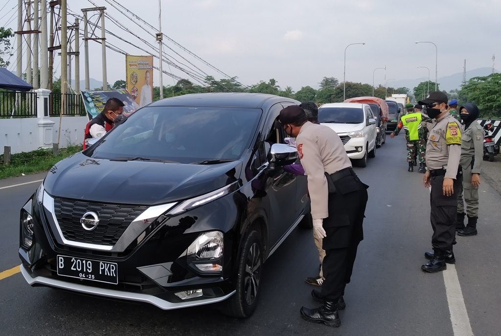 Personel gabungan saat memeriksa pengendara mobil di jalur perbatasan Cianjur-Bandung tepatnya di Jembatan Citarum, Haurwangi, Kabupaten Cianjur, Jawa Barat, Rabu (22/4/2020). (Foto: Angga Purwanda/dara.co.id)