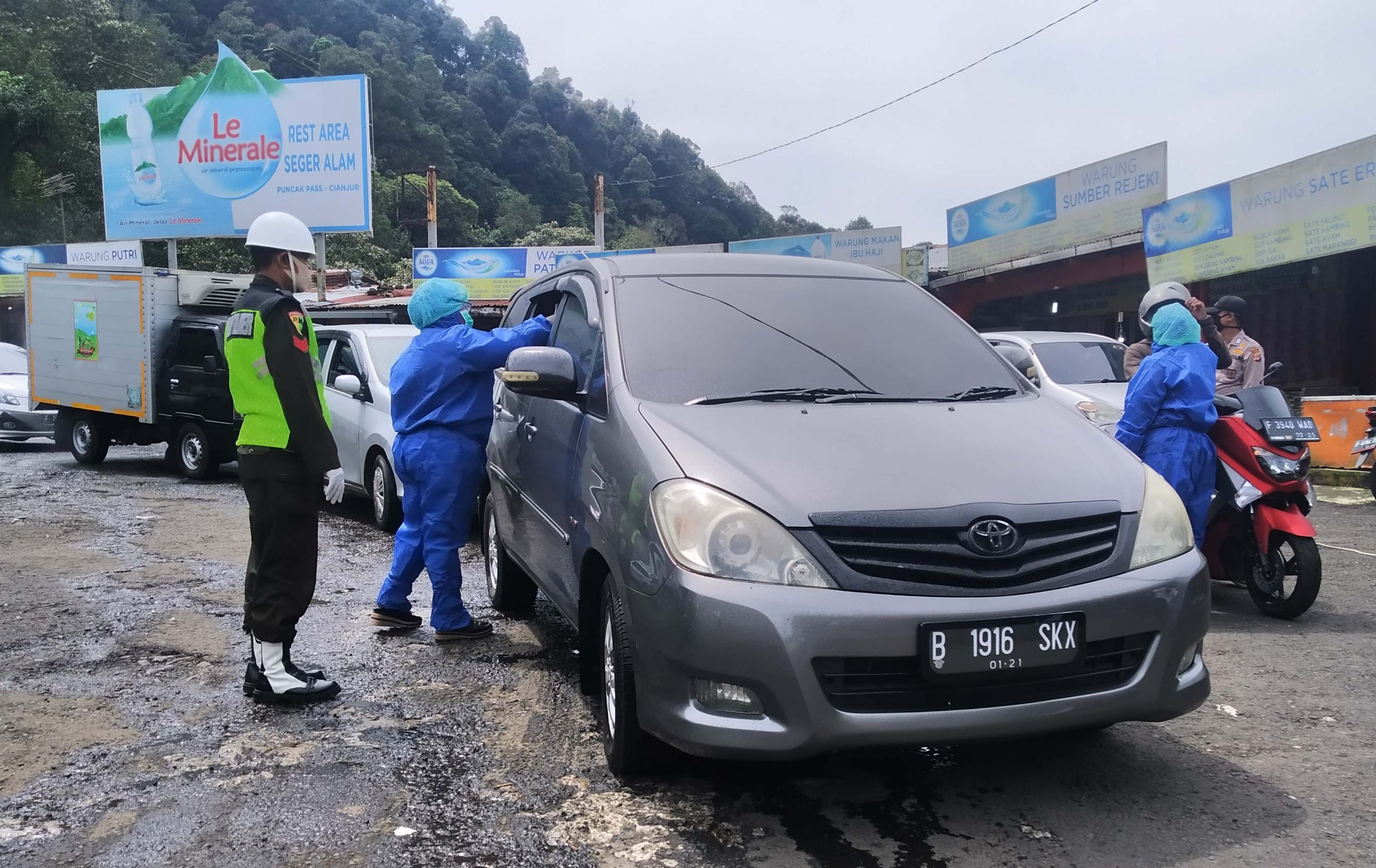 Petugas gabungan melakukan pemeriksaan kesehatan para pemudik yang melintas di Jalan Raya Cipanas-Puncak, Ciloto, Kabupaten Cianjur, Jawa Barat, Sabtu (25/4/2020). (Foto: Angga Purwanda/dara.co.id)