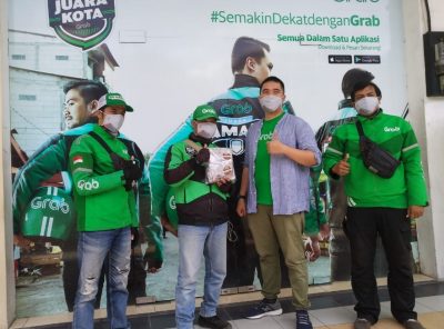 Perwakilan Telkom UNiversity menyerahkan bantuan ratusan masker secara simbolis kepada driver ojek online. (Foto: Humas Telkom University) 