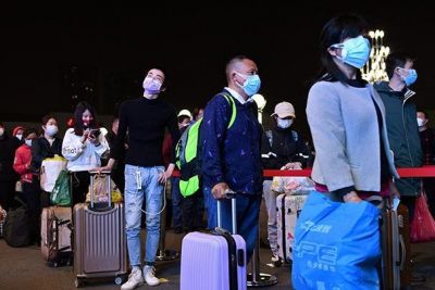 Para pelancong mengantre dengan membawa barang-barang mereka di luar Stasiun Kereta Api Wuchang, untuk meninggalkan Wuhan di ibu kota Provinsi Hubei, China, Selasa (7/4/2020). (Foto: Reuters/tempo.com)