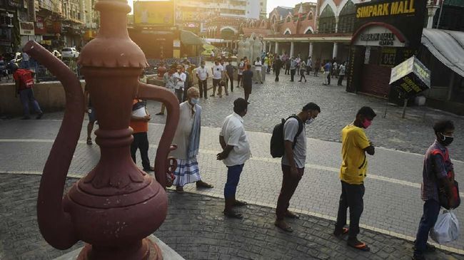 Warga di India mengantre di toko miras untuk membeli alkohol setelah pemerintah mulai melonggarkan lockdown virus corona. (AFP/DIBYANGSHU SARKAR)