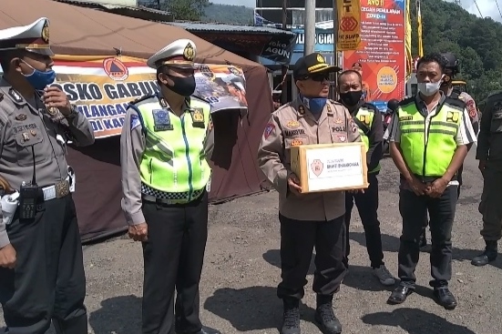 Kakorlantas Polri saat membagikan masker kepada personel di pos check point 1 Seger Alam, Ciloto Cipanas, Kabupaten Cianjur, Jawa Barat, Sabtu (30/5/2020).