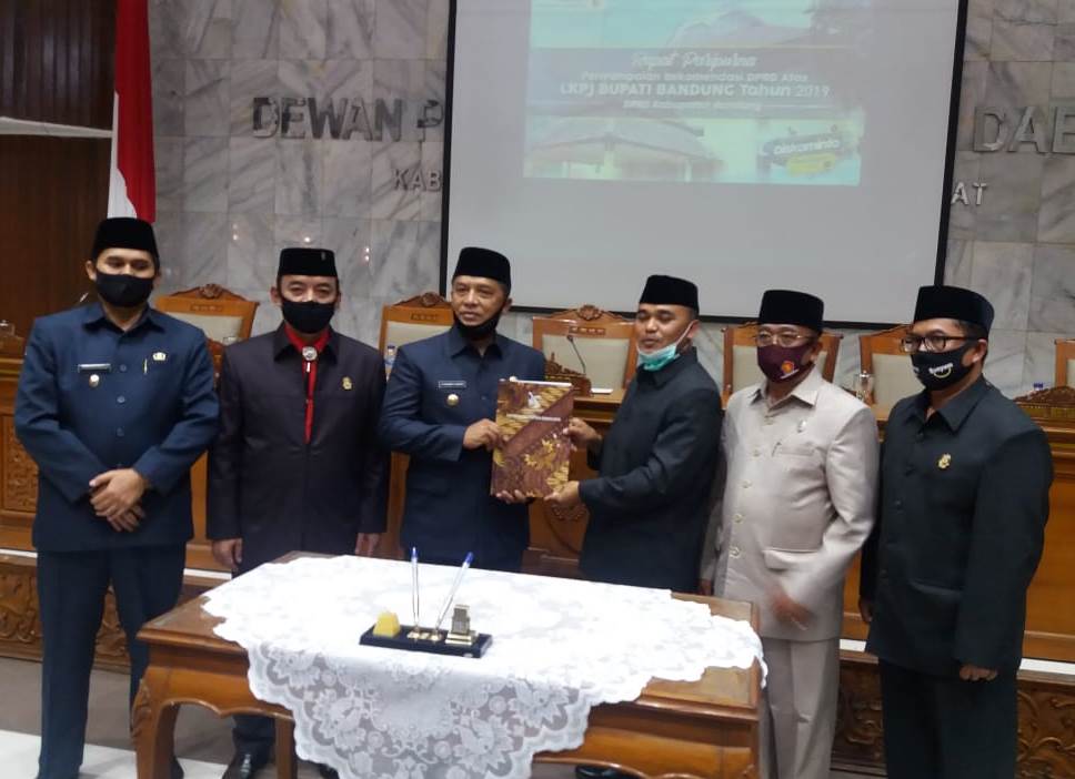 Bupati Bandung, H. Dadang M. Naser (ketiga kiri) menyerahkan LKPj Tahun 2019 kepada Ketua DPRD Kabupaten Bandung, Sugianto (ketiga kanan) dalam rapat paripurna yang digelar di Gedung Paripurna DPRD Kabupaten Bandung di Soreang, Kamis (28/5/2020). (Foto: Istimewa)