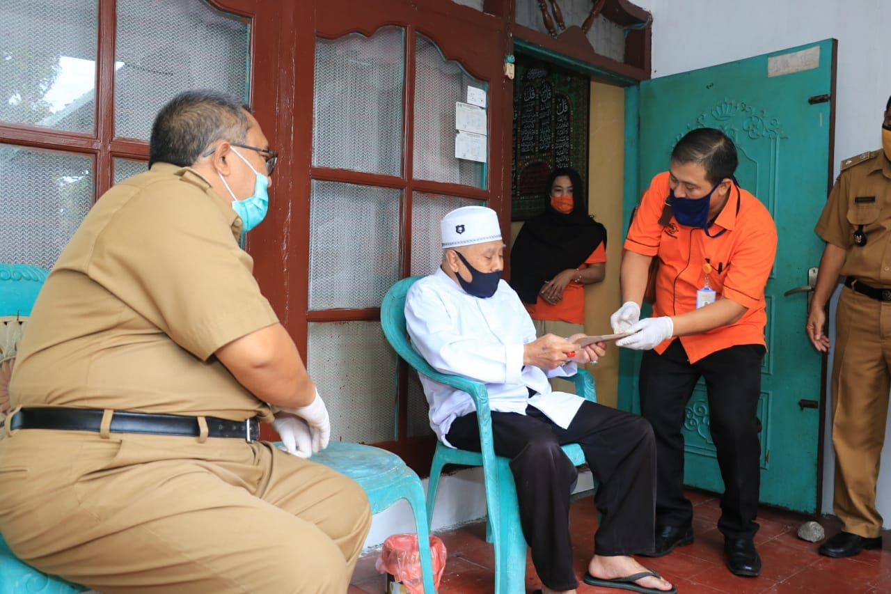 Bupati Sukabumi, Marwan Hamami (kiri) ikut langsung menyerahkan bansos tunai kepada warga di Kabupaten Sukabumi, Jawa Barat, Selasa (`9/5/2020). (Foto: Riri Satiri/dara.co.id)