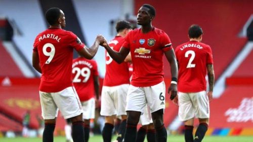 Anthony Martial berjabat tangan dengan rekannya Paul Pogba usai Manchester United mengalahkan Sheffield United dengan skor 3-0 di Stadion Old Trafford, Kamis (25/6/2020) dini hari WIB. (Foto: Twitter @ManUtd)