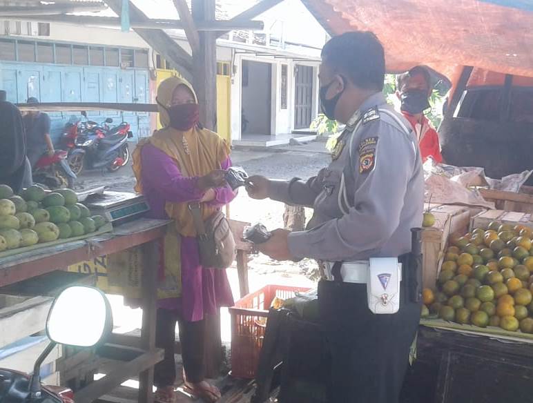 Seorang anggota Satlantas Polres Majalengka saat memberikan masker kepada pedagang pasar. (Foto: Yohanes Charles/dara.co.id)