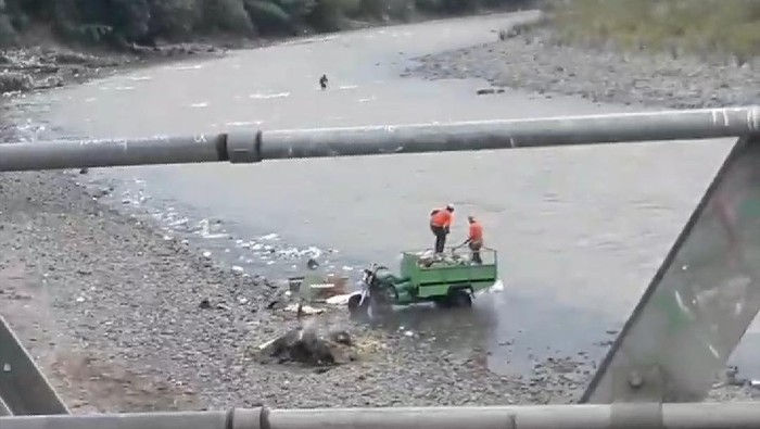 Dua orang diduga petugas kebersihan di Cianjur buang sampah ke sungai (Foto: Istimewa/Detik.com)