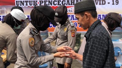 Anggota Polres Cianjur saat memberikan minuman nutrisi kepada warga usai salat Jumat. (Foto: Angga Purwanda/dara.co.id)