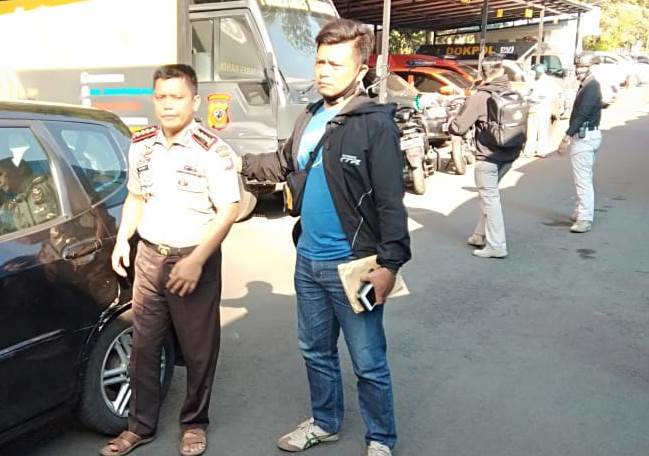 Anggota Polrestabes Bandung (kanan) menggiring tersangka penipuan yang mengaku sebagai polisi berpangkat Kombes. (Foto: Avilla Dwi Putra/dara.co.id)