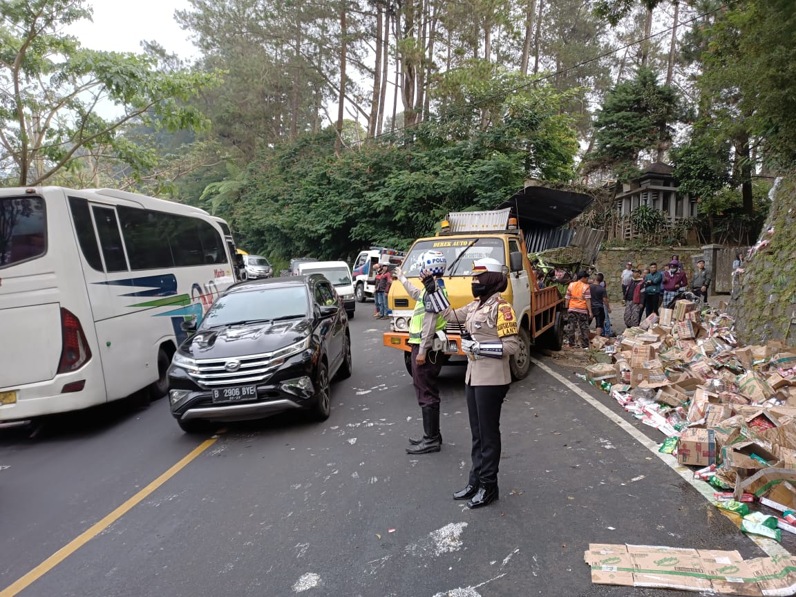 Dua anggota Satlantas Polres Cianjur mengatur arus lalu lintas di lokasi kecelakaan  di ruas Jalan Raya Puncak, Kampung Pengkolan RT 03/02, Desa Ciloto, Kecamatan Cipanas, Kabupaten Cianjur, Jawa Barat, Selasa (18/8/2020). (Foto: Angga Purwanda/dara.co.id)