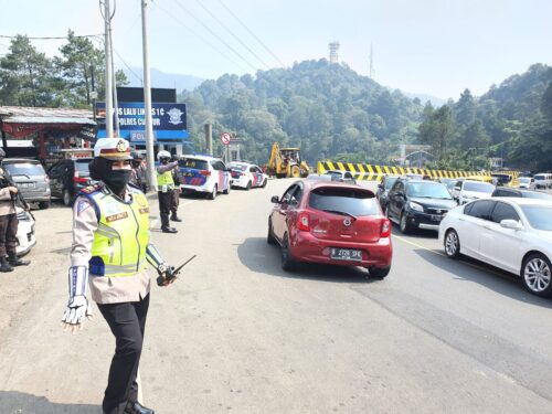  Kasatlantas Polres Cianjur, AKP Meilawaty saat melakukan pengaturan lalu lintas di jalur Puncak, Cipanas. Setiap pengendara wajib terapkan protokol kesehatan, di antaranya memakai masker. (Purwanda/dara.co.id) 