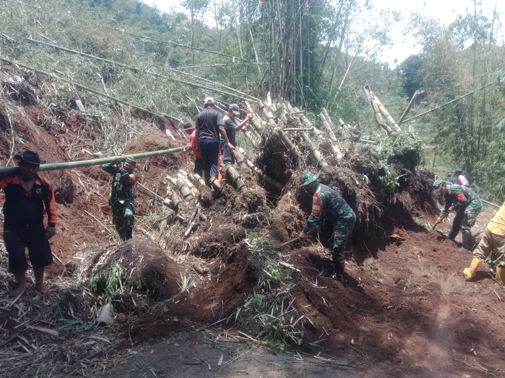 Anggota Babinsa Koramil 1107/Limbangan, bersama-sama warga sekitar tengah membersihkan material longsoran yang menutup jalan penghubung Kabupaten Garut dan Sumedang di Kampung Cirapuhan, Kecamatan Selaawi, Kabupaten Garut, Minggu (01/11/2020).  (Foto: Andre/dara.co.id)
