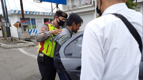 Pelaku upaya bunuh diri, TA (31), saat diamankan polisi usai melakukan aksinya di Jembatan Cimanuk, kawasan Jalan Pramuka, Kecamatan Garut Kota, Kabupaten Garut, Senin (14/12/2020). (andre/dara.co.id) 
