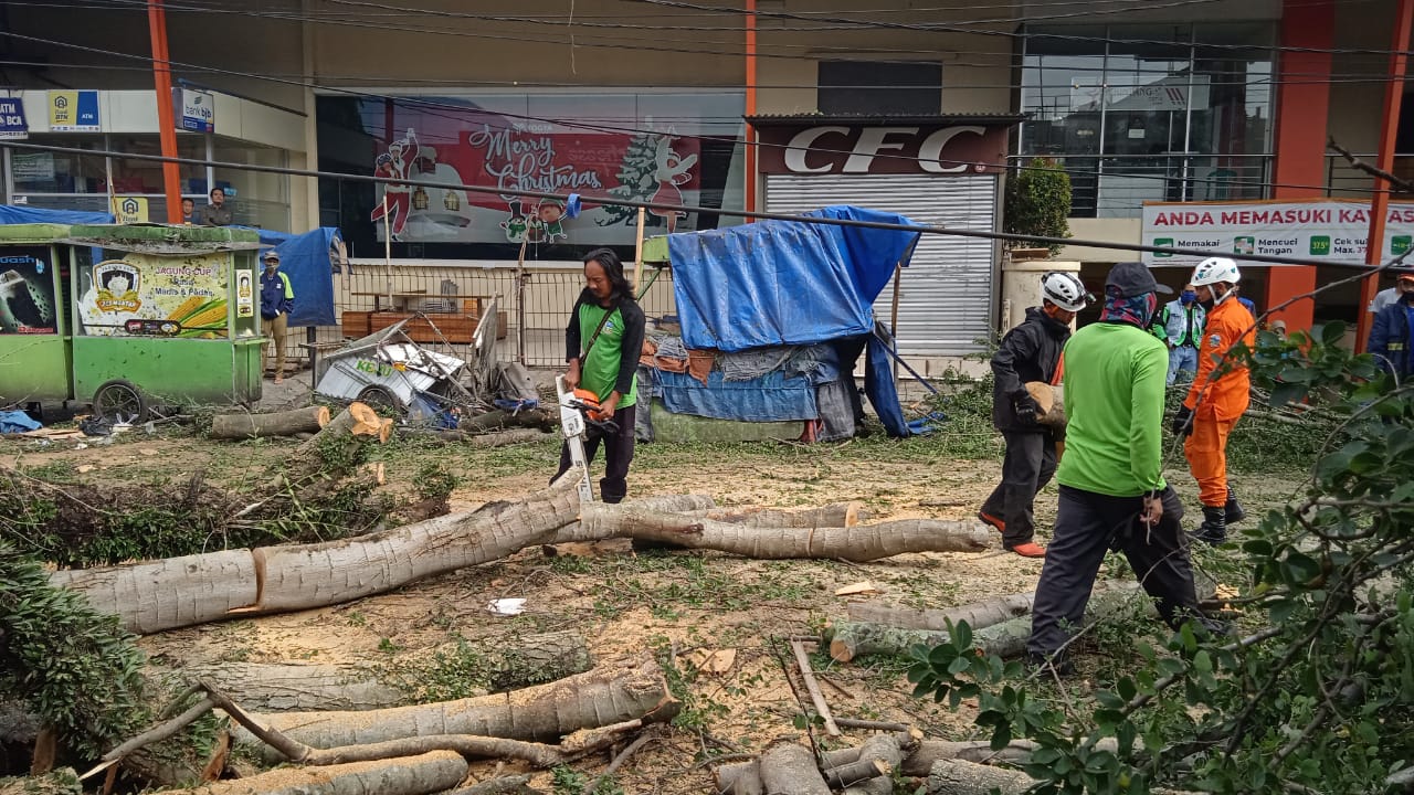 Pembersihan dan pemotongan material pohon tumbang di Jl. Siliwangi depan Toserb dan nomor antrian manual di Puskesmas Siliwangi, Kecamatan Garut Kota, Kabupaten Garut, Senin (4/1/2021). (Foto: Andre/dara.co.id)
