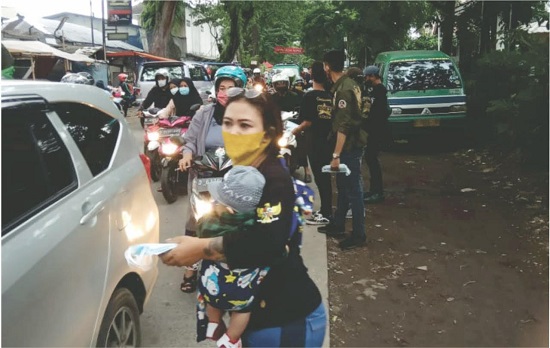 Ibu Uci bagikan masker di pinggir jalan sambil menggendong bayinya (Foto: Istimewa)