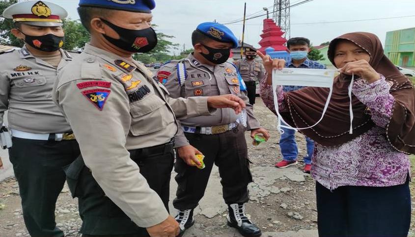 Anggota Polresta Cirebon saat melaksanakan kegiatan pembagian masker kepada masyarakat langsung (Foto: Bambang Setiawan/dara.co.id)