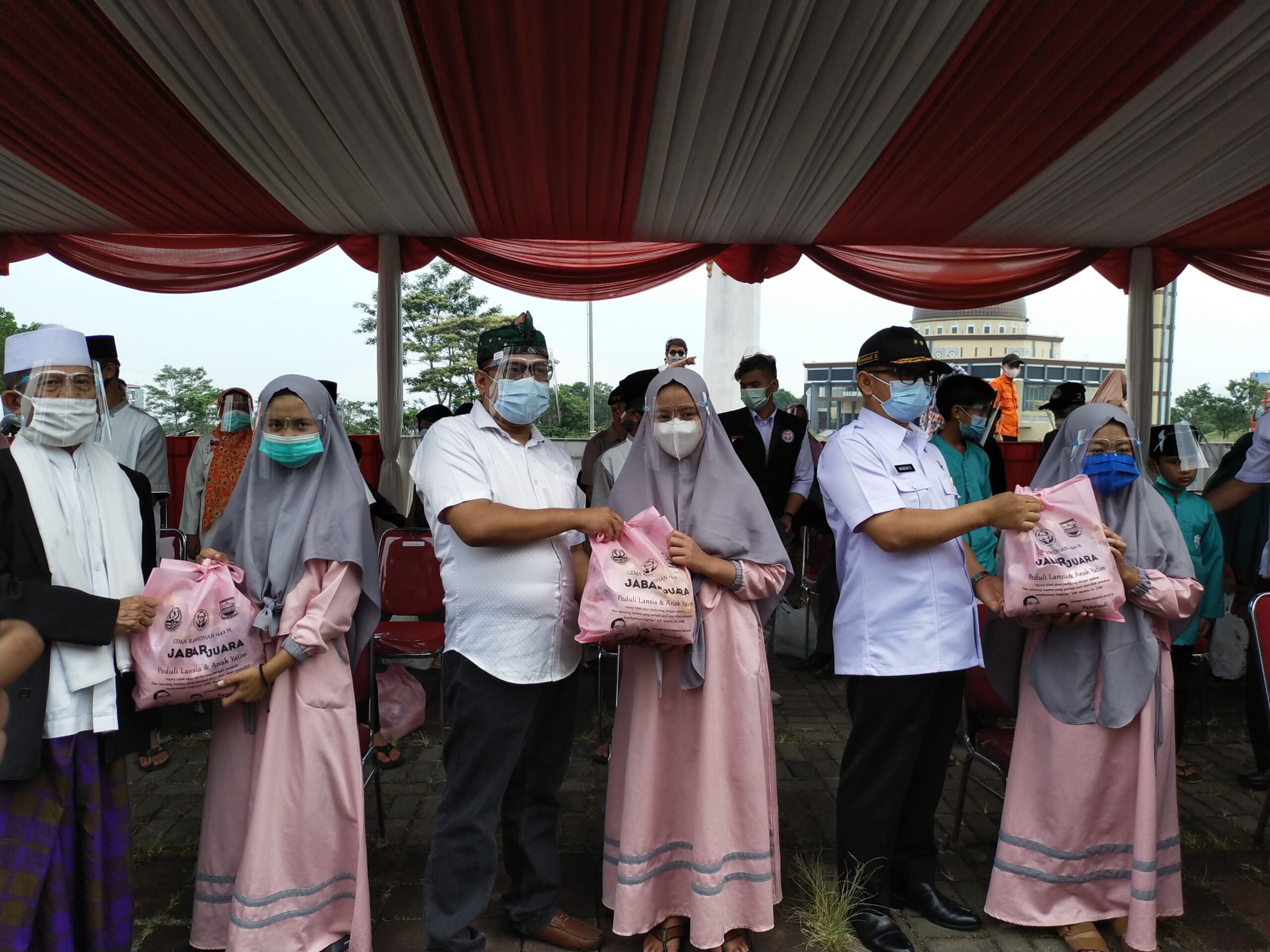 Pamriadi menyerahkan paket sembako pada salah seorang yatim piatu (Foto: Istimewa)