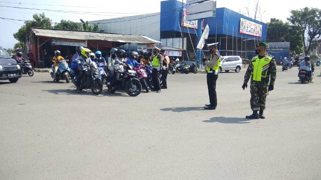 

Petugas sedang memutarbalikkan pengendara yang hendak berwisata di Jalan A Yani, Palabuhanratu, Kabupaten Sukabumi, Jawa Barat, Minggu (16/5/2021). (Foto : riri/dara.co.id)
