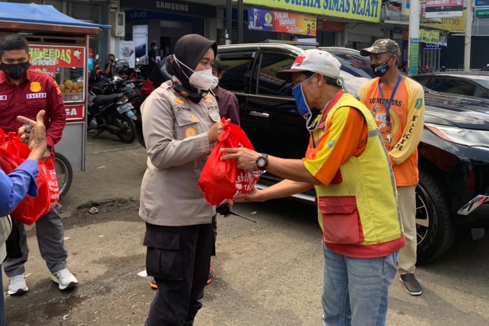 
Kapolres Sukabumi Kota AKBP Sumarni memberikan paket sembako kepada petugas parkir, Jumat (25/5/2021). (Foto: riri/dara.co.id)
