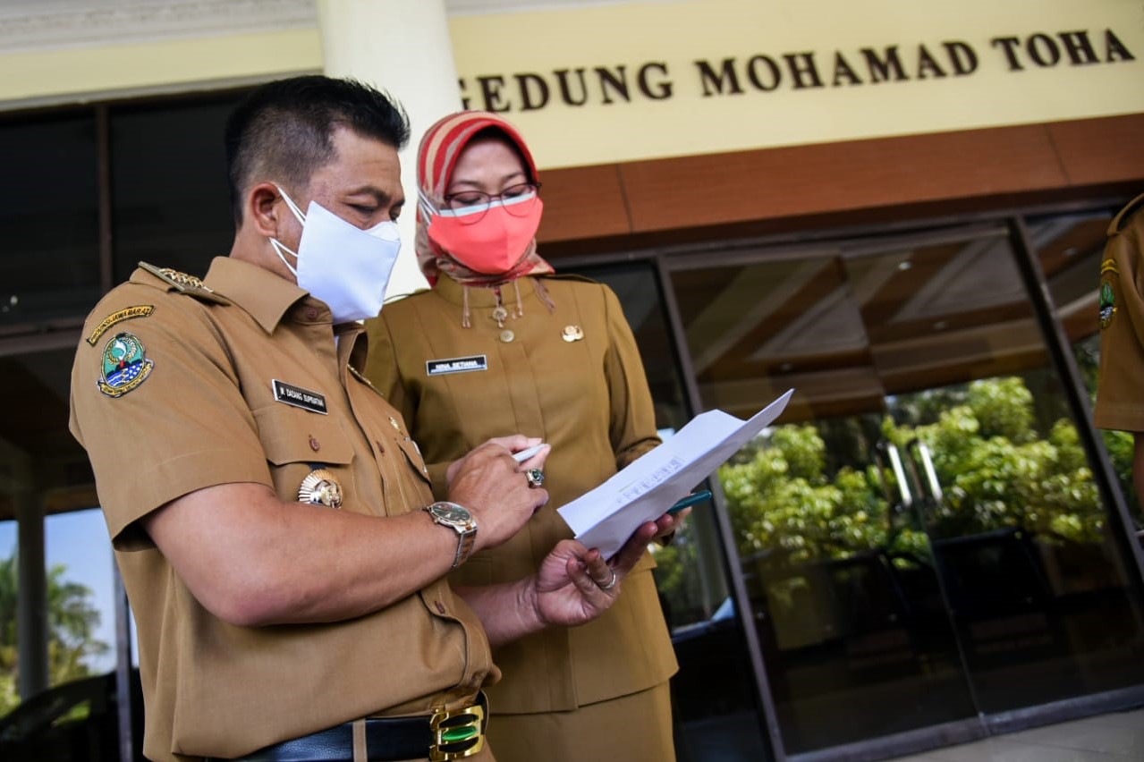 Bupati Bandung HM Dadang Supriatna didampingi Kepala Dinsos, Nina Setiana. mecermati data penerima paket sembako bagi warga yang melakukan isolasi mandiri di rumah, Bantuan tersebut dilepas bupati di halaman Gedung Moh. Toha, (5/7/2021). (Foto: Humas Pemkab Bandung)

