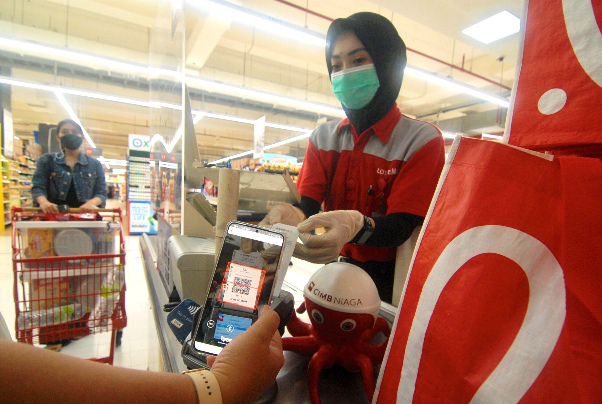 Nasabah melakukan transaksi pembayaran belanja menggunakan Scan QRIS OCTO Mobile dari CIMB Niaga. Di tengah Pemberlakuan Pembatasan Kegiatan Masyarakat (PPKM) saat ini, nasabah yang harus berkegiatan di luar rumah seperti untuk berbelanja kebutuhan pokok, dapat memanfaatkan fitur pembayaran Scan QRIS OCTO Mobile. Aktivitas belanja menjadi lebih sehat dan aman karena dilakukan secara nontunai dan tanpa kontak fisik, serta tersedia pula penawaran menarik cashback 20% (Foto: Istimewa)