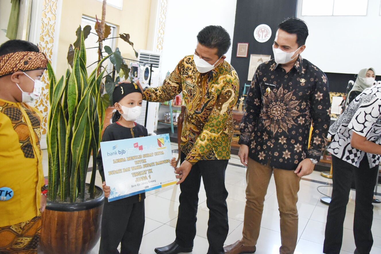 
Bupati Bandung Dadang Supriatna didampingi Wakil Bupati Sahrul Gunawan menyerahkan hadiah juara baca puis kepada Nizam Adriansyah dari SD Panundaan, di Rumah Jabatannya, Soreang, Kamis (9/9/2021). (Foto: Humas Pemkab Bandung)
