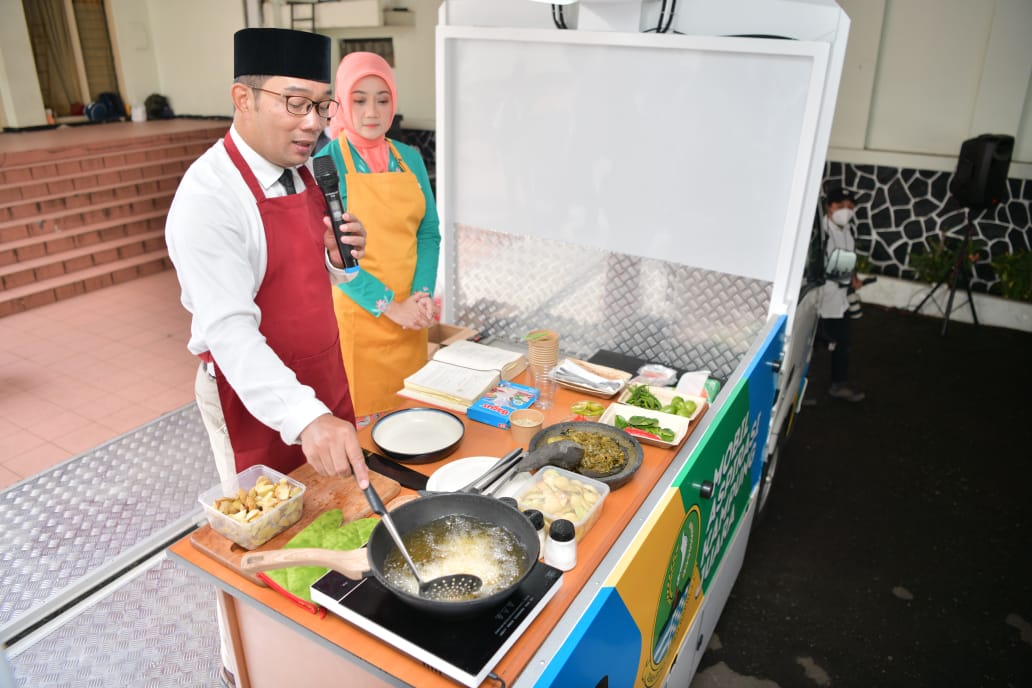 
Gubernur Jabar Ridwan Kamil disaksikan istrinya Atalia Praratya saat menunjukkan kebolehannya dalam memasak di Gedung Merdeka, Kota Bandung, Rabu (22/12/2021).(Foto: deram/dara.co.id)
