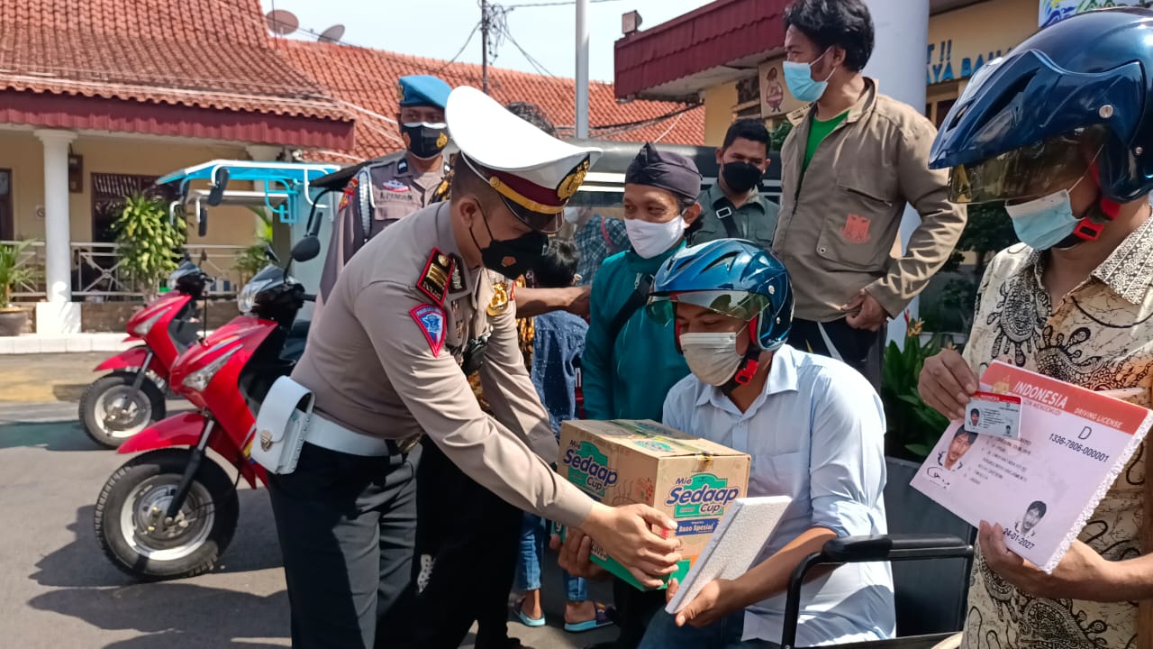 Kasat Lantas Polres Cirebon Kota AKP Triyono Raharja menyerahkan bantuan sembako kepada penyandang disabilitas (Foto: Istimewa)