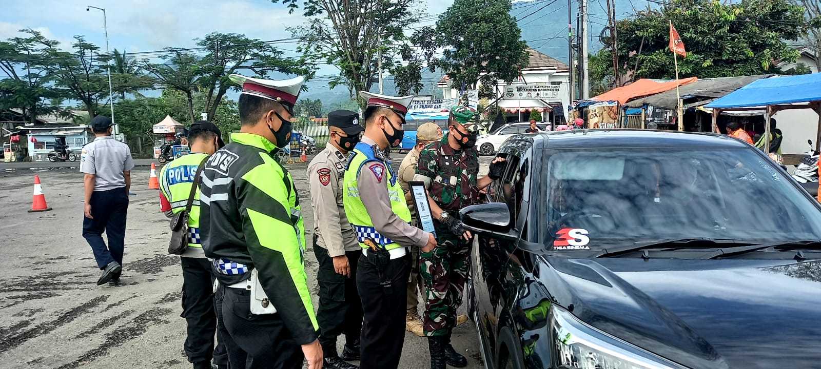 

Petugas gabungan melakukan pemeriksaan kepada pengendara dan wisatawan yang masuk Garut di Pos Pantau Kadungora, Sabtu (1/1/2022).(Foto: andre/dara.co.id)
