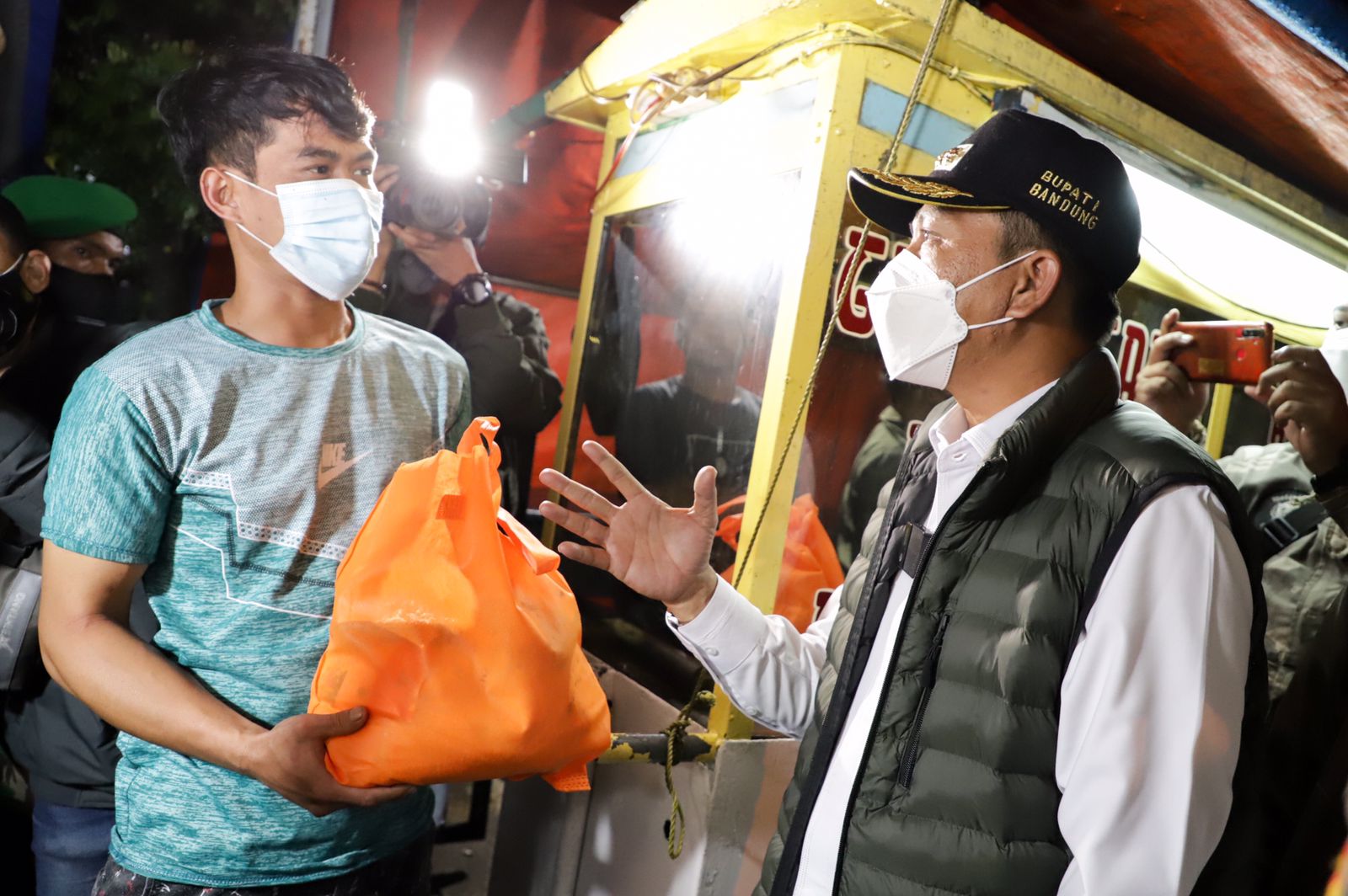 Bupati Dadang Supriatna membagikan sembako kepada pedagang kaki lima, saat inspeksi mendadak (sidak) bersama Forkopimda kei sejumlah kawasan di Kabupaten Bandung, Rabu (16/2/2022) malam.
(Foto : Humas Setda)
