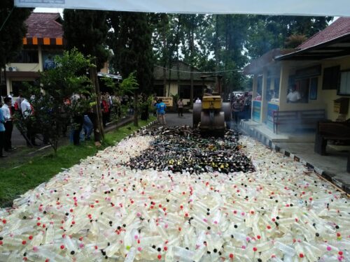 Jelang Ramadan, ribuan botol miras dan knalpot bising dimusnahkan dengan cara digilas menggunakan alat berat di halaman Mako Polres Garut, Jalan Sudirman, Kecamatan Karangpawitan, Kabupaten Garut, Jumat (1/4/2022). (Foto: andre/dara.co.id) 
