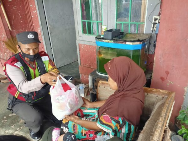 Bripka Yayat Sudrajat sebagai Bhabinkamtibmas Desa Cangkuang Polsek Cangkuang Polresta Bandung, membagikan beras dan kue kaleng kepada warga, Jumat  (3/6/2022) (Foto: Istimewa)