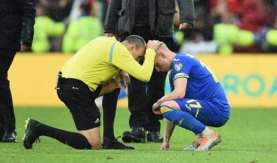 Wasit asal Spanyol Antonio Miguel Mateu Lahoz (kiri) menghibur pemain Ukraina Oleksandr Zinchenko selepas laga playoff Piala Dunia 2022 kontra Wales, Senin (6/6/2022) dini hari WIB. (Foto: Ist)
