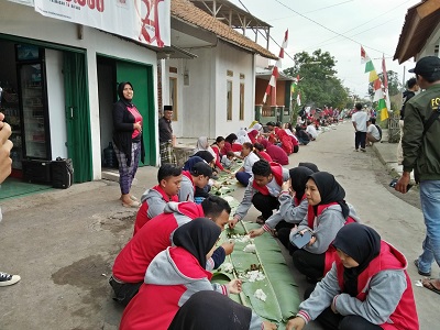 Ribuan warga Desa Sukasenang, Kecamatan Banyuresmi, Kabupaten Garut makan bersama atau botram di jalan desa sepanjang 877 meter dalam memeriahkan HUT RI ke-77, Minggu (21/8/2022).(Foto: andre/dara.co.id)