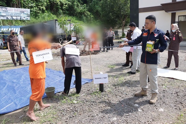 
Tersangka meperagakan beberapa adegan dalam proses rekonstruksi kasus pembunuhan kuswanto di halaman parkir satlantas polres Banjar. (Foto: Istimewa)